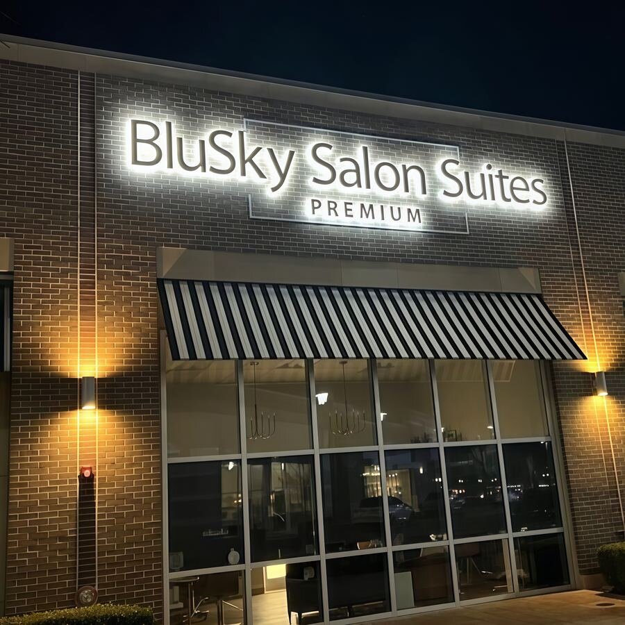 BluSky Salon Suites white backlit channel letters on dark brick exterior at night