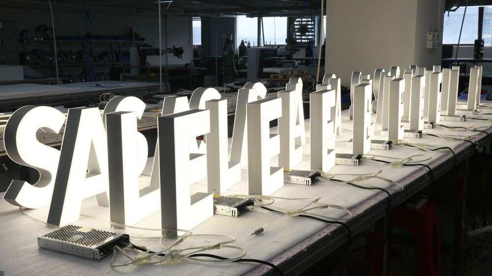 Channel letters burn-in testing bench with illuminated LED signs and power supplies