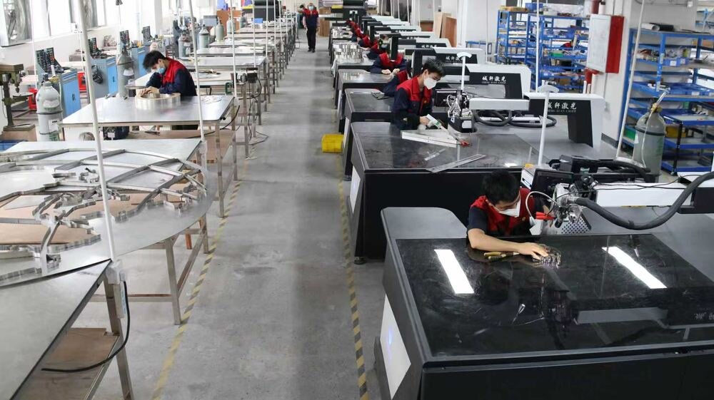 Channel letters production workshop floor with CNC machines and skilled workers