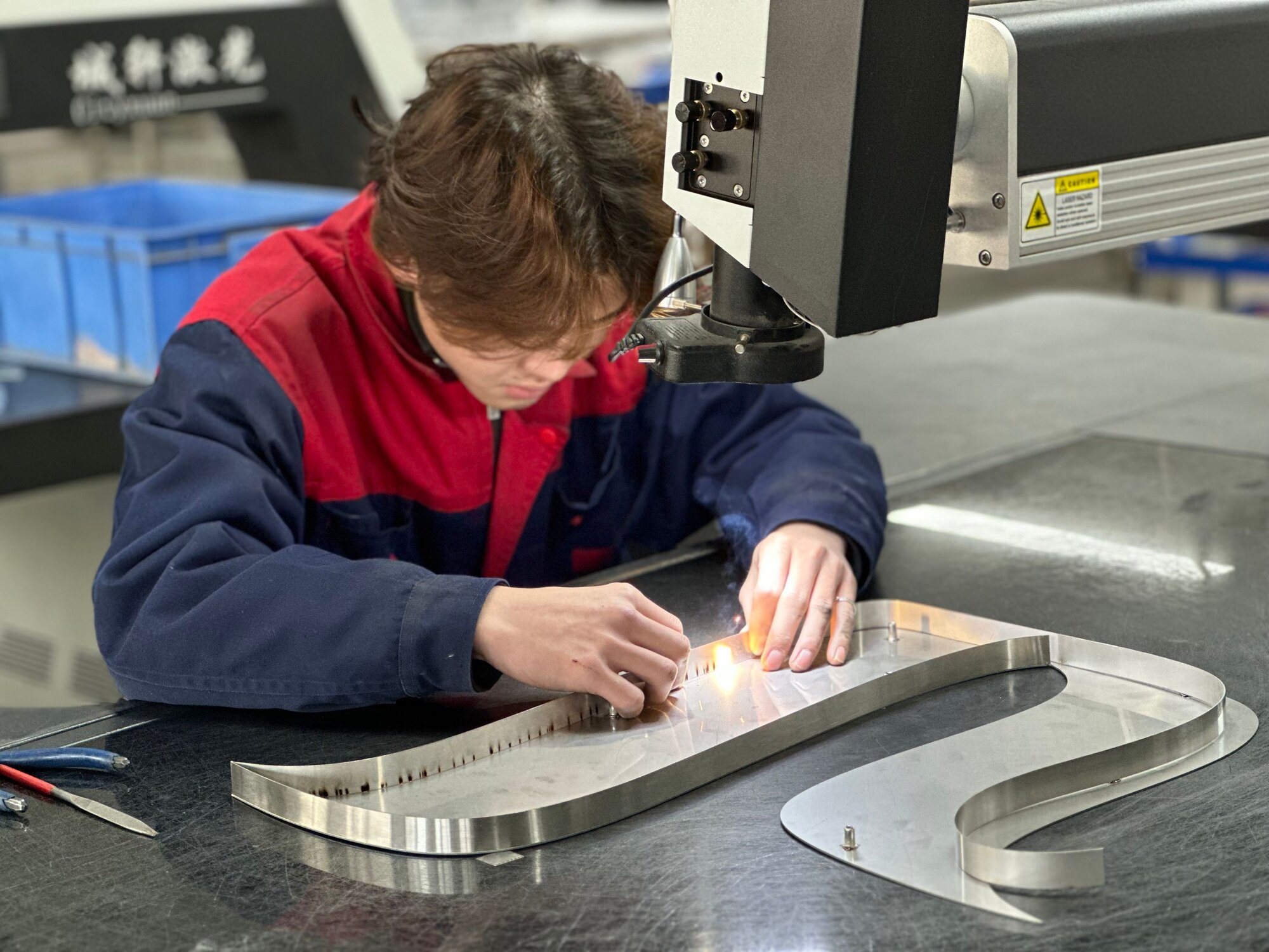Skilled craftsman laser welding stainless steel channel letter returns, precision fabrication