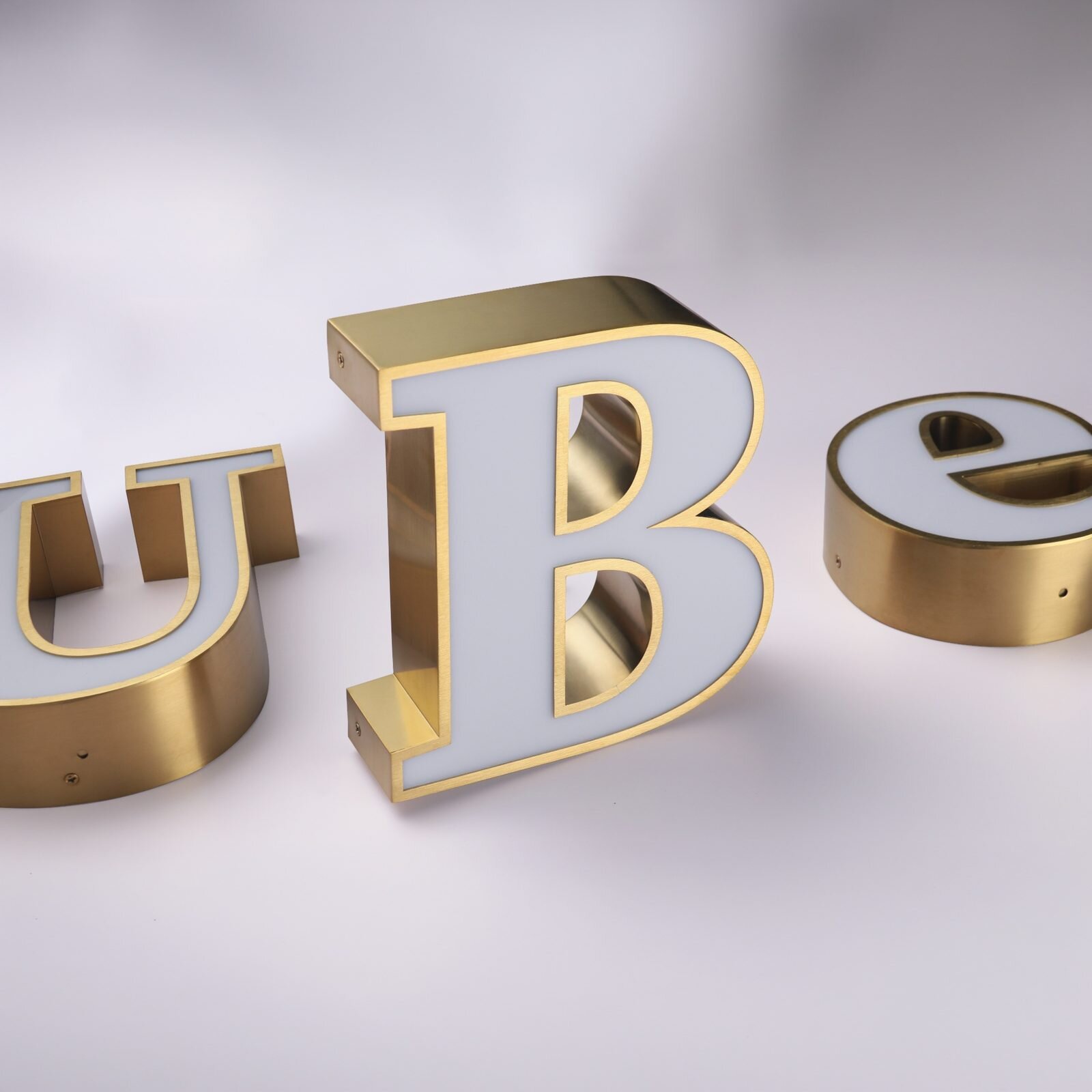 Gold trim custom channel letters showing welded metal returns, acrylic face, and sealed construction