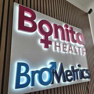 Pink and blue backlit channel letters on wood accent wall