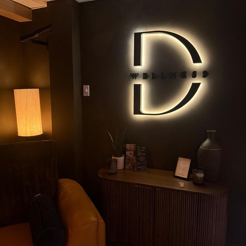 Backlit LED logo sign on dark accent wall, Canada customer installation