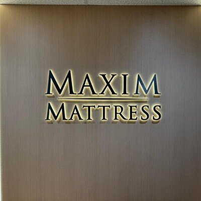 Warm halo-lit channel letters on wood feature wall, office installation