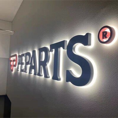 Black backlit channel letters on interior gray wall, customer installation