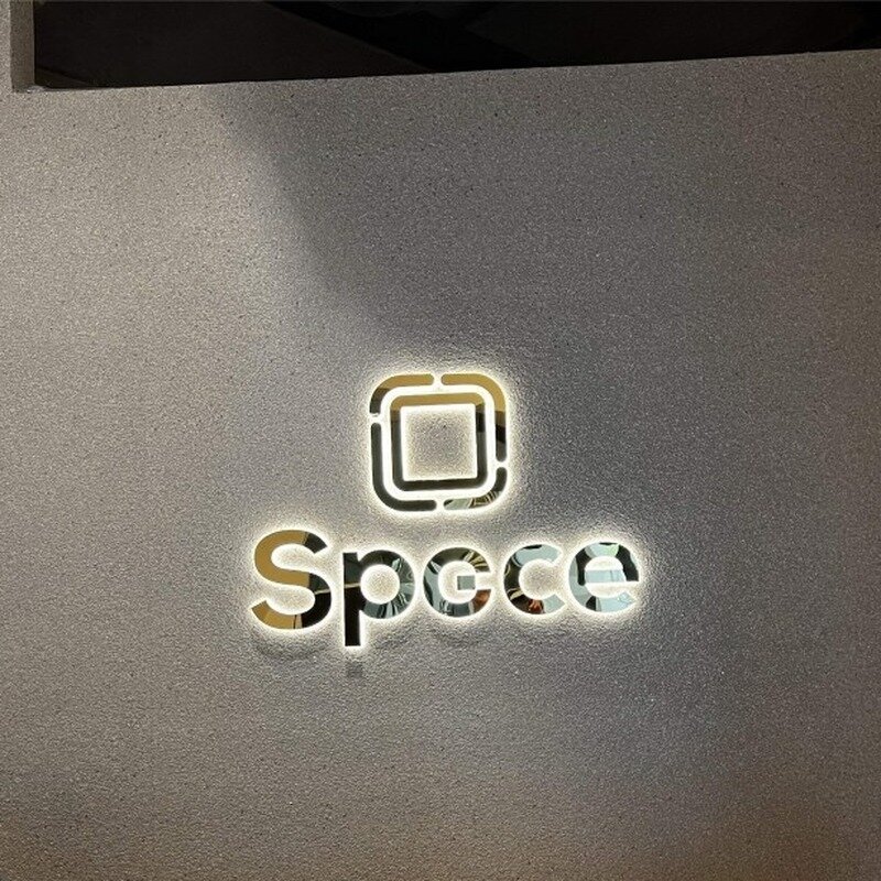 Gold mirror backlit channel letters on textured gray wall, Europe customer installation